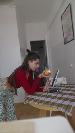 woman examining an apple in a kitchen.