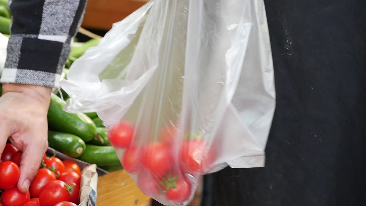 persona comprando tomates cereza en una tienda de comestibles