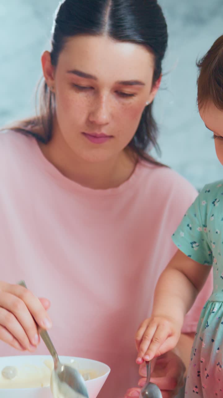 A nurturing moment in the kitchen as a caregiver prepares a meal while a child's hand reaches in to help with the ingredients, capturing the essence of family bonding through cooking