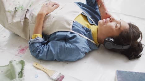 Video-of-biracial-female-artist-in-headphones-resting-in-studio