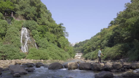 el hombre caminaba sobre las rocas del arroyo