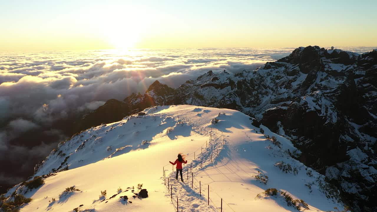 una mujer corre por el camino nevado en la cima de la montaña pico ruivo en madeira