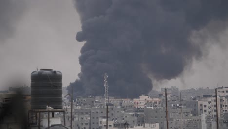 Thick-black-smoke-rises-high-among-buildings-destroyed-by-Israeli-missile-attacks-in-the-Gaza-Strip