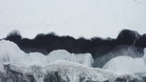 冰島黑沙灘的美麗無人機拍攝顯示海浪高潮和的天氣,而雪覆蓋了部分黑沙