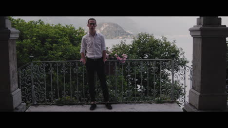 man on a balcony with a lake view