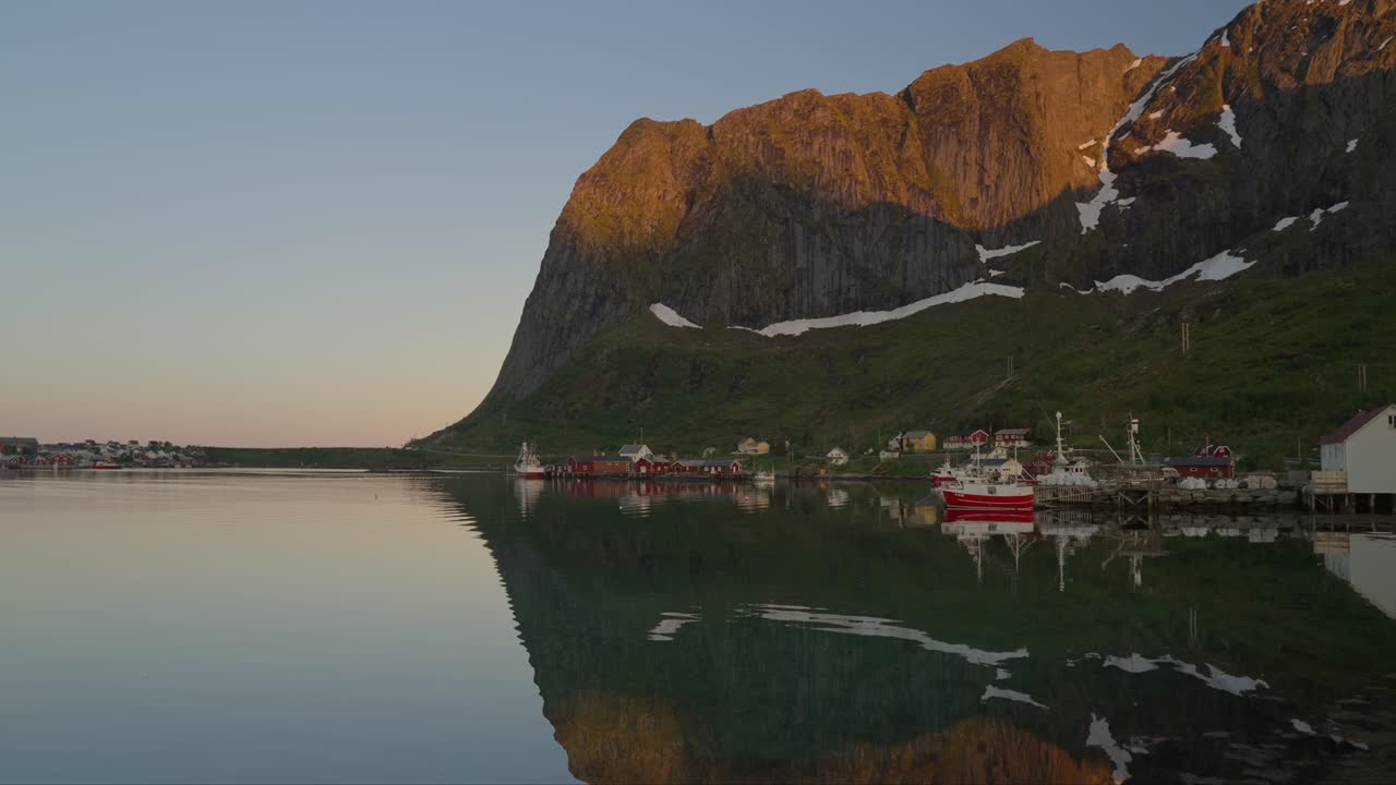 pueblo pesquero de reine con reflejos de las montañas en lofoten en la hora dorada