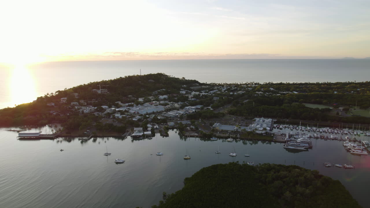 Aerial tracking shot of the townscape of Port Douglas, golden hour in Australia