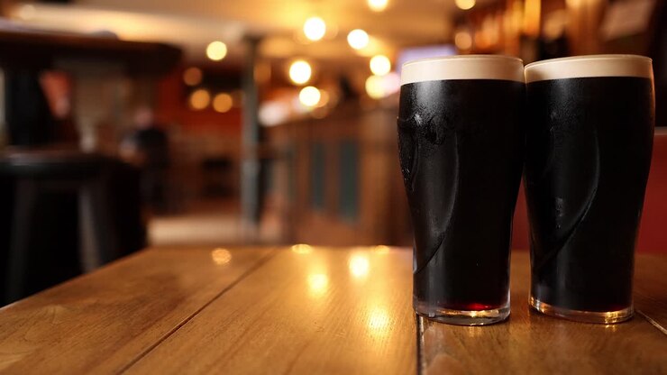 Due pinte di stout su un tavolo da pub