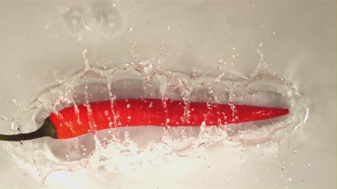 Red Chili Pepper Splashing into Water in Slow Motion