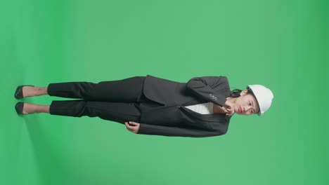 full body of asian female engineer thinking about something and looking around then raising her index finger in the green screen studio