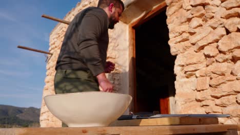 Man-prepares-table-by-setting-a-plate