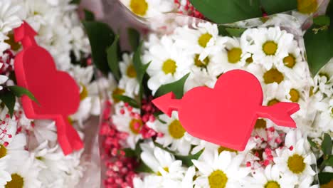 romántico ramo de margaritas blancas con decoraciones de corazón y flecha rojas