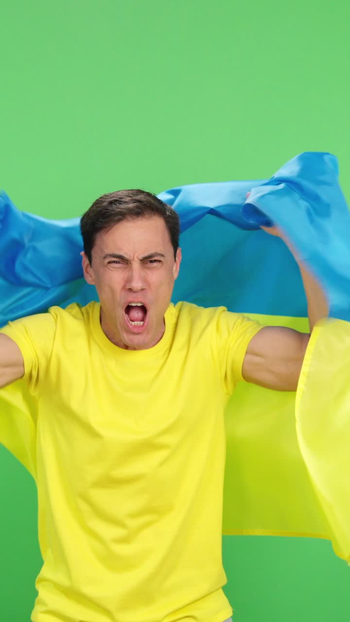 Ukrainian fan celebrating with flag on green screen