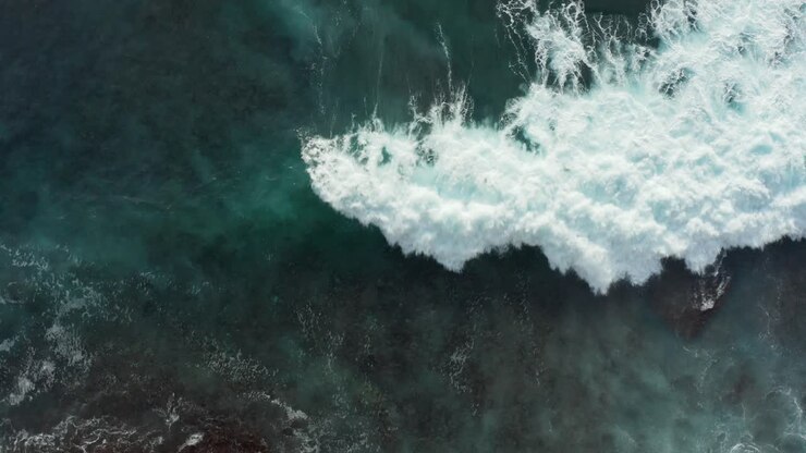 Beautiful aerial top down view of clear turquoise blue ocean water covering reef rocks