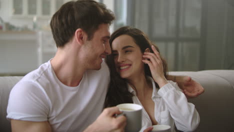 una pareja feliz relajándose con café en casa.