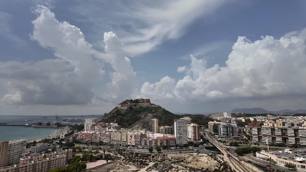 Panoramic time lapse left to right of Alicante City, Spain, with a view of the city center, the castle and Mediterranean sea in a summer day with some clouds in a blue sky.4K