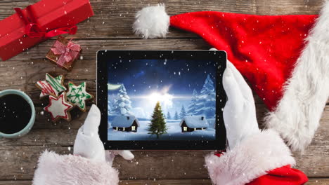 Videokomposition-Mit-Schnee-über-Der-Draufsicht-Des-Weihnachtsmanns,-Der-Ein-Tablet-Hält