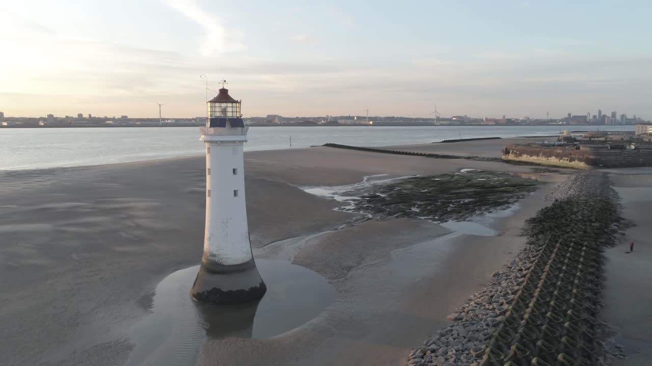 vista aérea a través del faro británico y el astillero del puerto costero grúas amanecer horizonte órbita derecha