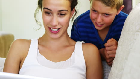 mujeres sonrientes y su hijo mirando la computadora portátil