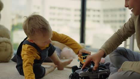 happy boys arranging race with toy cars at home. cheerful boy playing indoors.