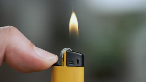 hand lights the lighter. blazing lighter in hand on super slow motion.