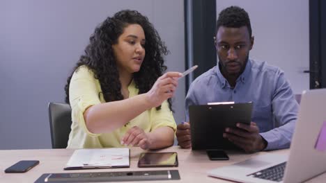 Happy-diverse-couple-of-business-people-working-together-in-modern-office