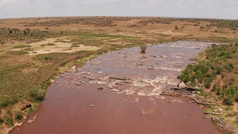 Toma-Aérea-Con-Drones-Del-Paisaje-Africano-De-Masai-Mara-Hermoso-Paisaje-Fluvial-En-La-Reserva-Nacional-Masai-Mara-En-Kenia,-áfrica,-Estableciendo-La-Toma-Después-Del-Agua-Que-Fluye