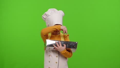 Child-girl-cook-chef-baker-in-apron-and-hat-adding-raisins-to-dough-in-bowl,-preparing-bread,-cake