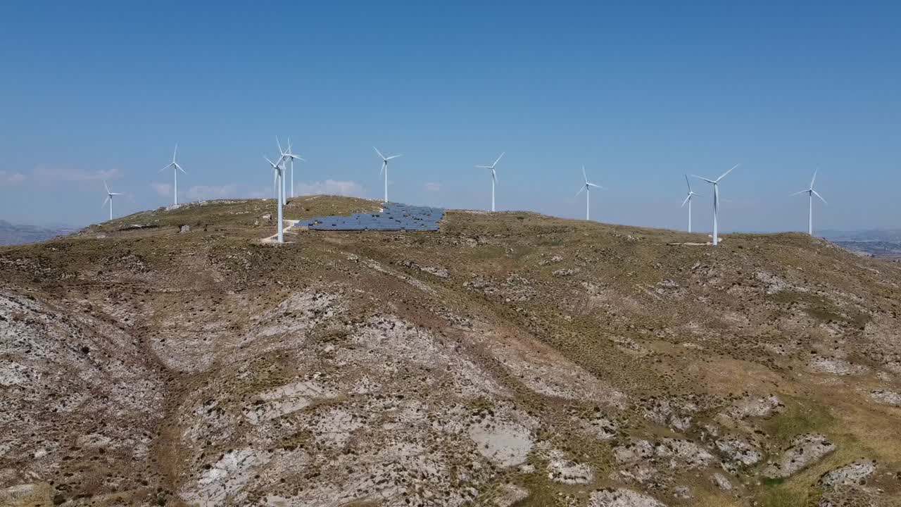 vista aérea del paisaje montañoso con turbinas de energía eólica y granja solar durante un hermoso día soleado