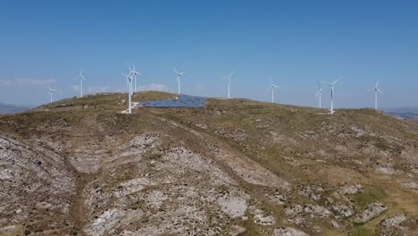 aerial view of mountain landscape with wind power turbines and solar farm during beautiful sunny day