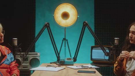young podcaster interviewing female guest in audio recording studio
