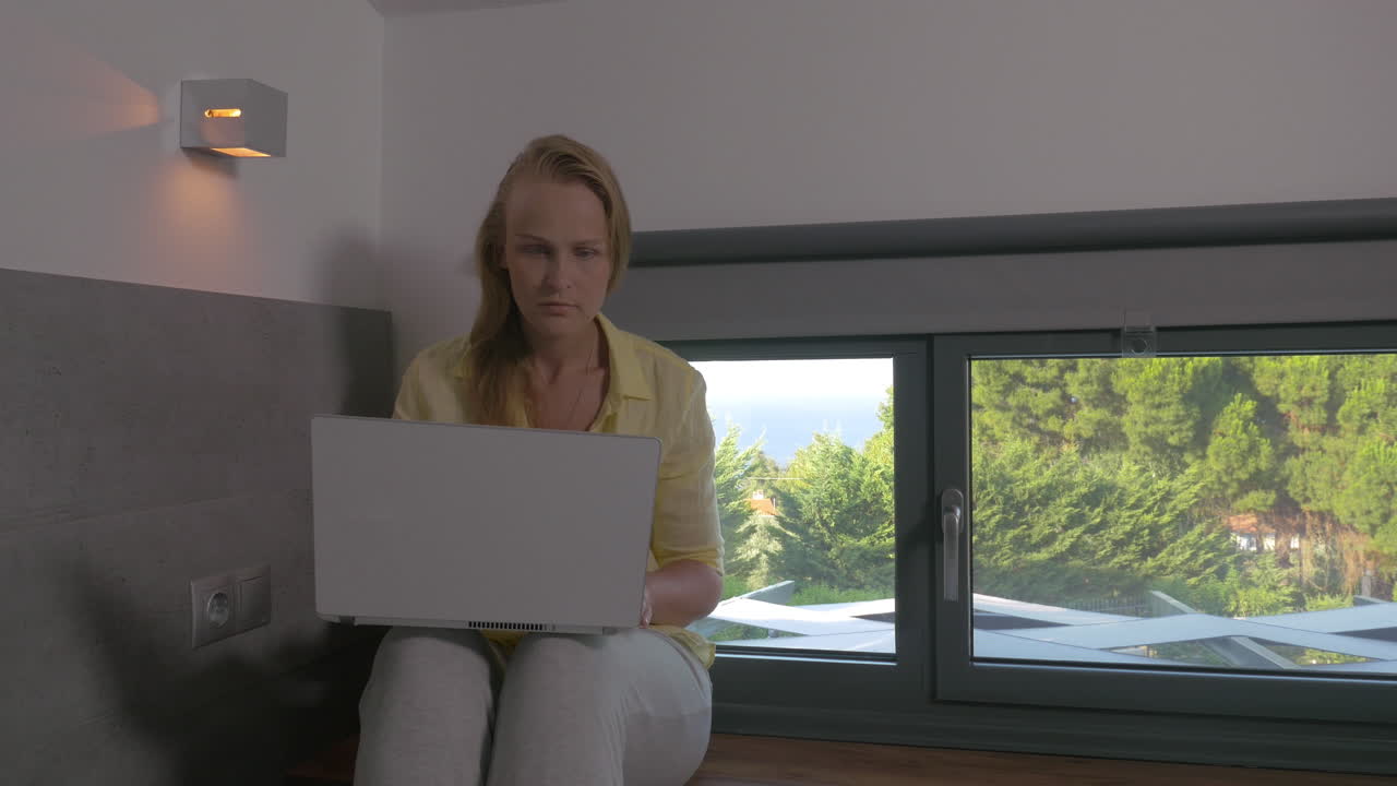 Blonde woman working on laptop