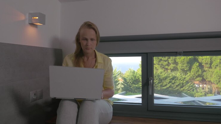 Blonde woman working on laptop