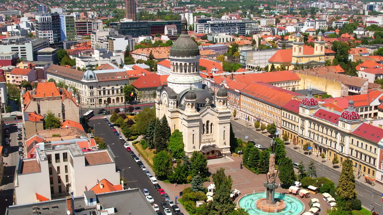 Vista aérea de drone da Catedral Ortodoxa localizada na Praça Avram Iancu, no centro de Cluj Napoca, Romênia. Paisagem urbana, praça central, prédios antigos, carros