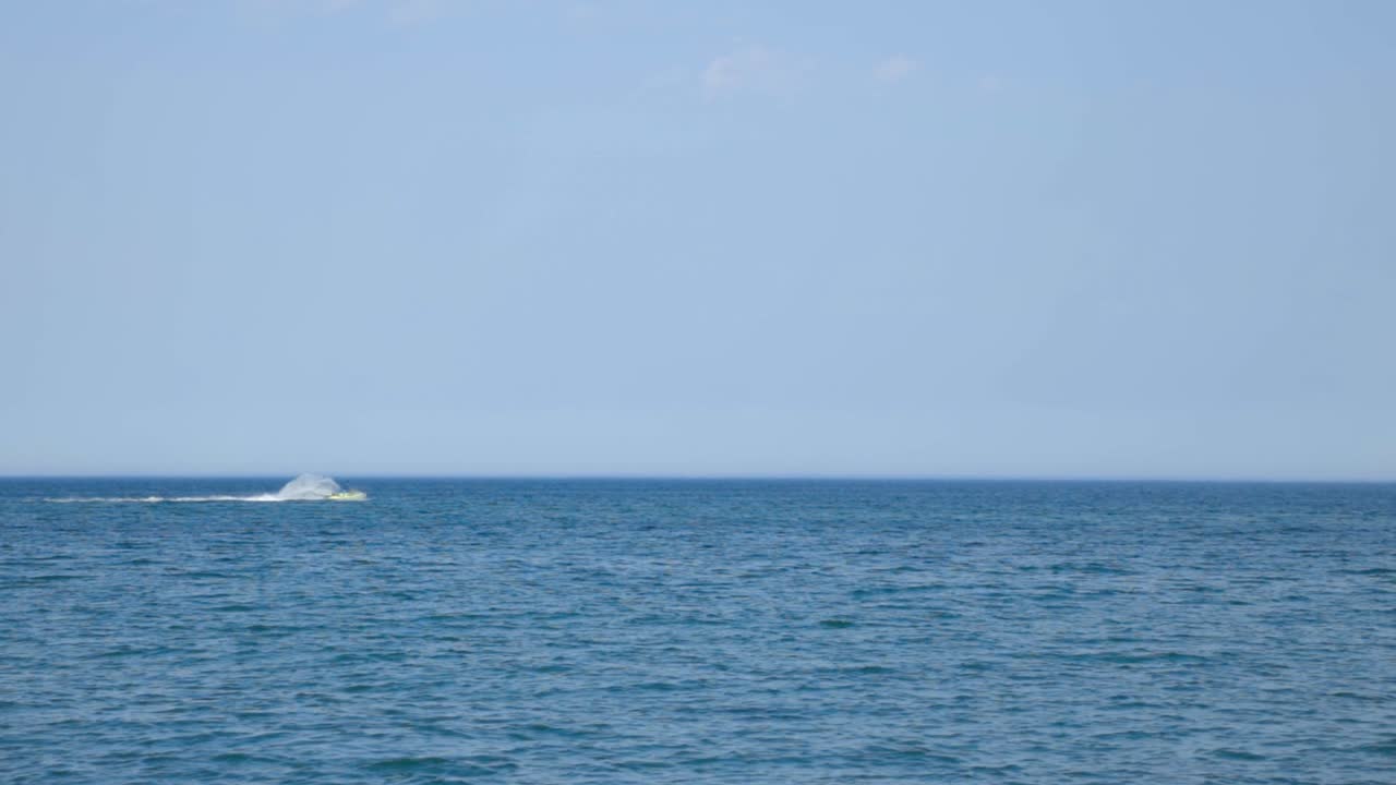 Jetskiing Over The Deep Blue Sea On Hot Summer Day - An Extreme Watersports Adventure - wide shot