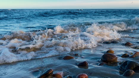 Stormy-Baltic-Sea-with-crashing-waves-against-sandy-beach-and-rocks-on-shore,Poland