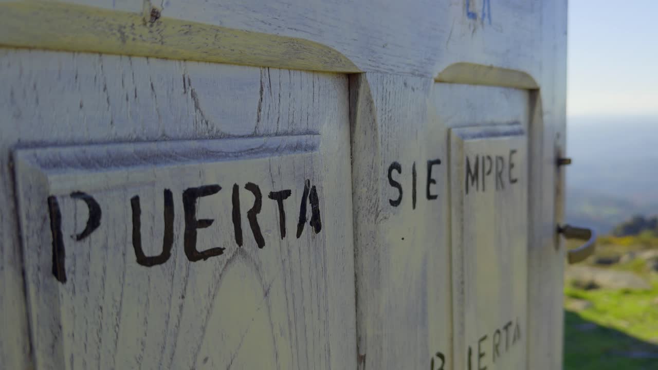 cerrar una puerta de madera blanca con dos palabras escritas en la cima de una montaña