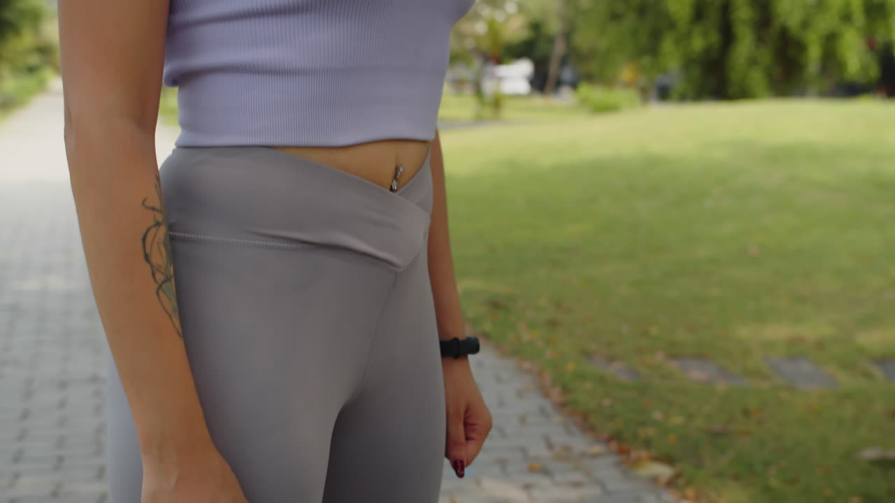 Unrecognizable Woman Checking App on Tracker after Morning Jog in Park
