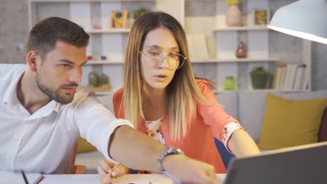 una pareja de arquitectos que trabajan en una oficina en casa preparan y discuten un proyecto de dibujo.