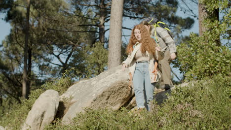 two young female backpackers hiking together in the forest on a sunny day