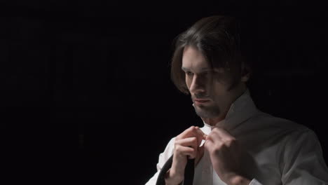 man adjusting tie in formal wear