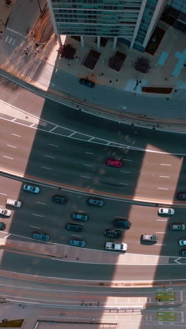 quick and busy traffic on the wide-lane roads of chicago. birds' eye view on the highway between skyscrapers and green park. vertical video