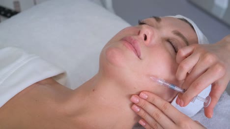 Woman receiving facial injection treatment