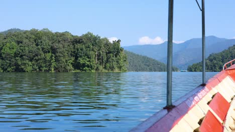 boat moving towards a lush green island