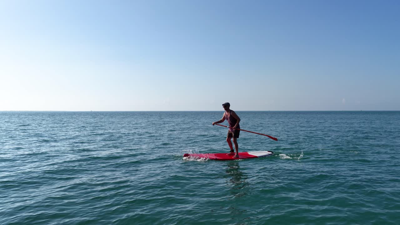 Sportsman paddling on sup board in calm sea