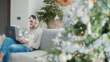 man listens to music on headphones and works remotely online during christmas