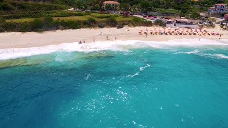 Petani-beach-with-turquoise-waters-and-beachgoers-in-kefalonia,-greece,-aerial-view