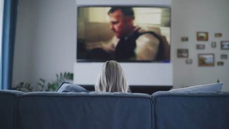 woman watching tv on sofa