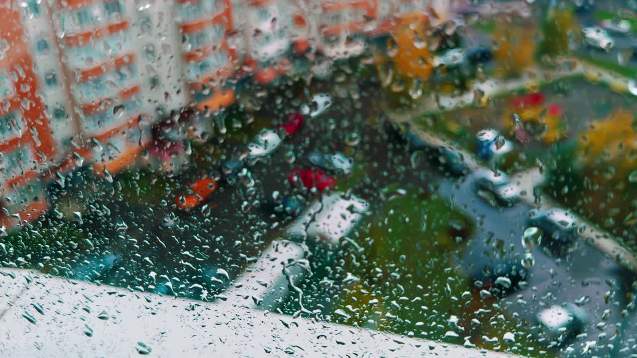 Yard of the residential area in the city from top floor. Rain dripping by the glass. Close up.