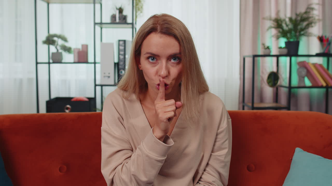 mujer joven presiona el dedo a los labios hace silencio signo de silencio no dice chismes secreto, tranquilo en casa